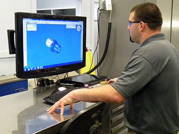 Shop-floor lead programmer, Matt Smith uses GibbsCAM Cut Part Rendering to inspect internal features of an upper spring holder that is pressed into the base mount of the antenna on military Hummers