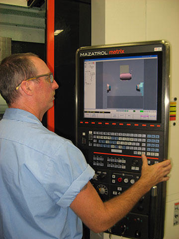 Todd Card, Instron first shift senior NC machinist, sets up a job on the Mazak Integrex. Because Mr. Welch prefers to keep the machine’s carousel loaded with tools for machining aluminum, it takes Mr. Card no more than 5 minutes to set up a job, unless a chuck change is required.