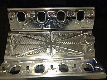 Manifold valley and flanges machined from billet show the pattern VoluMill creates when it generates the most efficient toolpath motion for running at maximum RPM and feed rate, while machining the 1/2” deep pockets in a single pass. Switzer leaves the machined finish to demonstrate part quality and beauty.