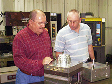 Gordon Tubbs (left), tooling designer and Scott Cain (right), programmer, look over the core and cavity after machining.