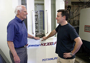 Two generations of Rasmussens discuss best machining approaches using Neal Feay’s newest machining center—a dual-pallet, 4-axis Kitamura Mycenter HX300iF horizontal. Neal Rasmussen, left, took the company into chassis manufacture and Alex, has moved the company into engineering and industrial design.