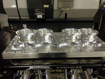 The upper components of a type of intake manifold made by Switzer Dynamics, showing the machine finish left from programming with GibbsCAM VoluMill, a high speed machining module that enables fast programming and fast machining, while extending tool life.