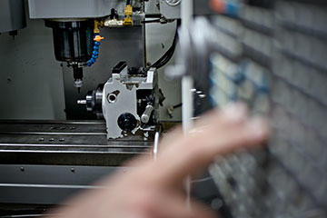 Machinist Tim Robison prepares one of AutoPilot’s three Haas Super Mini Mills for a four-axis operation on a surgical drill which he programmed with GibbsCAM.