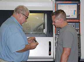 Mike Mullins, abrasive-plated tool production supervisor (left) and operator Fred Wooley inspect one of Sunnen's HPH tools automatically programmed using the GibbsCAM plug-in for machining on the Mazak Integrex 100.