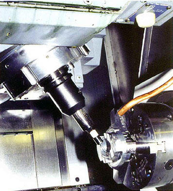 A small hole is drilled at an angle in the tapered inner wall of this compression tool blank using a small-diameter drill mounted in the turning center's tool spindle.