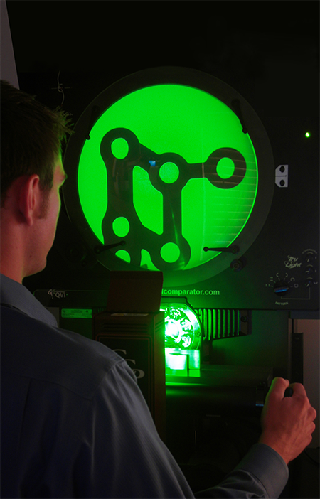 TraTek’s Shaun Smyser inspects dimensional accuracy of a finished orthopedic plate on an optical comparator.