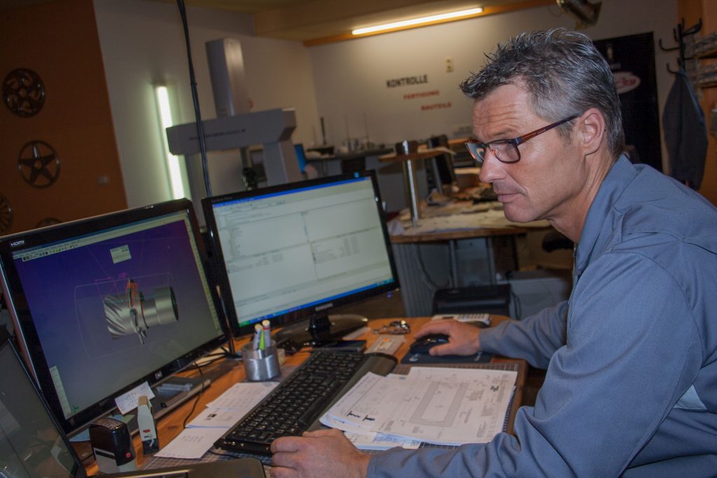Frank Gheorghiu am NC-Programmierplatz. Mit Virtual Gibbs behält er auch bei Änderungen an komplexen Bearbeitungen, die aus bis zu 350 Operationen bestehen, den Überblick.