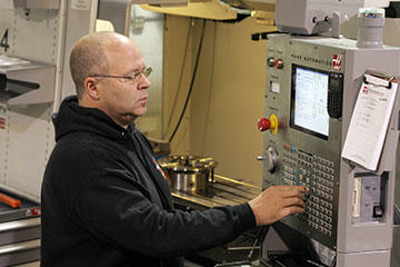 Scott Tudury executes a program at the Haas VF-4 machining center. GibbsCAM software permits programs to be optimized, revised, or updated even by the machine operator.