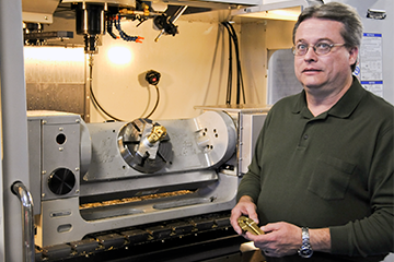 Craig Bidwell, with Haas VM-3 and TR-210 trunnion in background, teaches SolidWorks for design and GibbsCAM for multi-axis NC programming and machine simulation at Nash Community College.