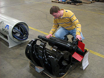 Design engineer Nathan Lindeman makes a final inspection of the swivel assembly of a guided boring machine. In the foreground is the auger weldment incorporating an end cap produced via four-axis machining and an auger flighting produced via Y-offset, four-axis machining.